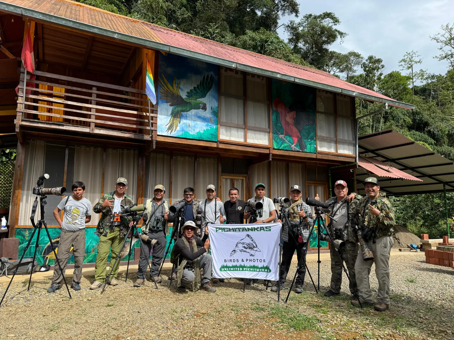 Birdwatchers with cameras and scopes at a forest lodge