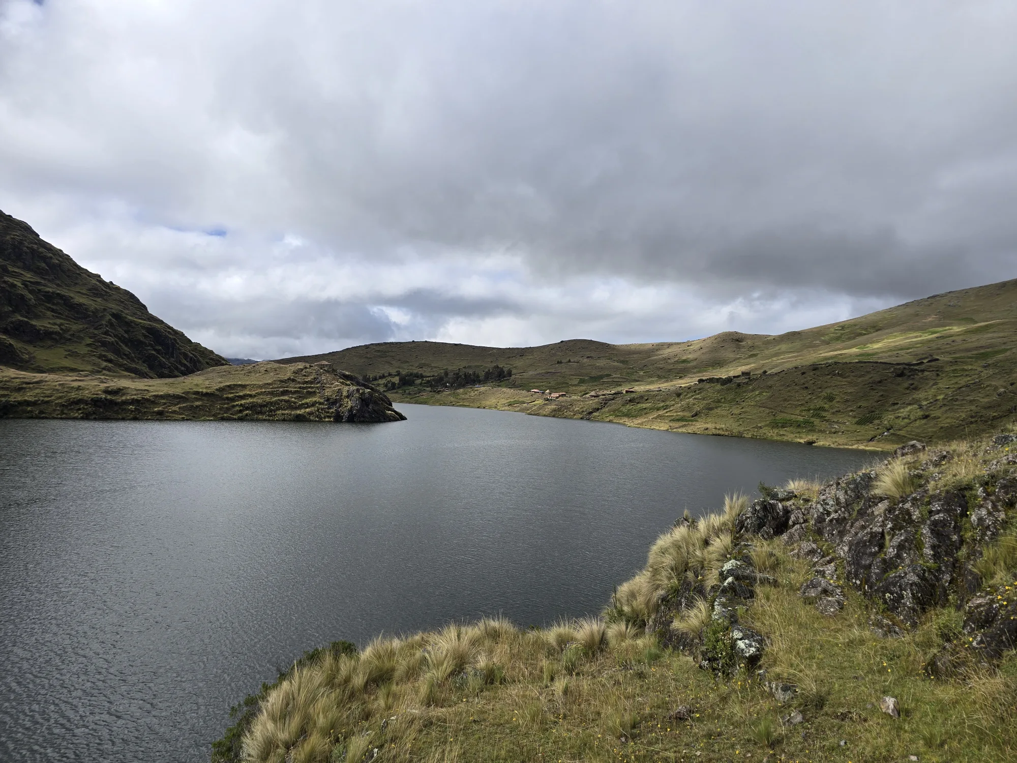 An Andean lagoon surrounded by hills, high in the Cusco backcountry